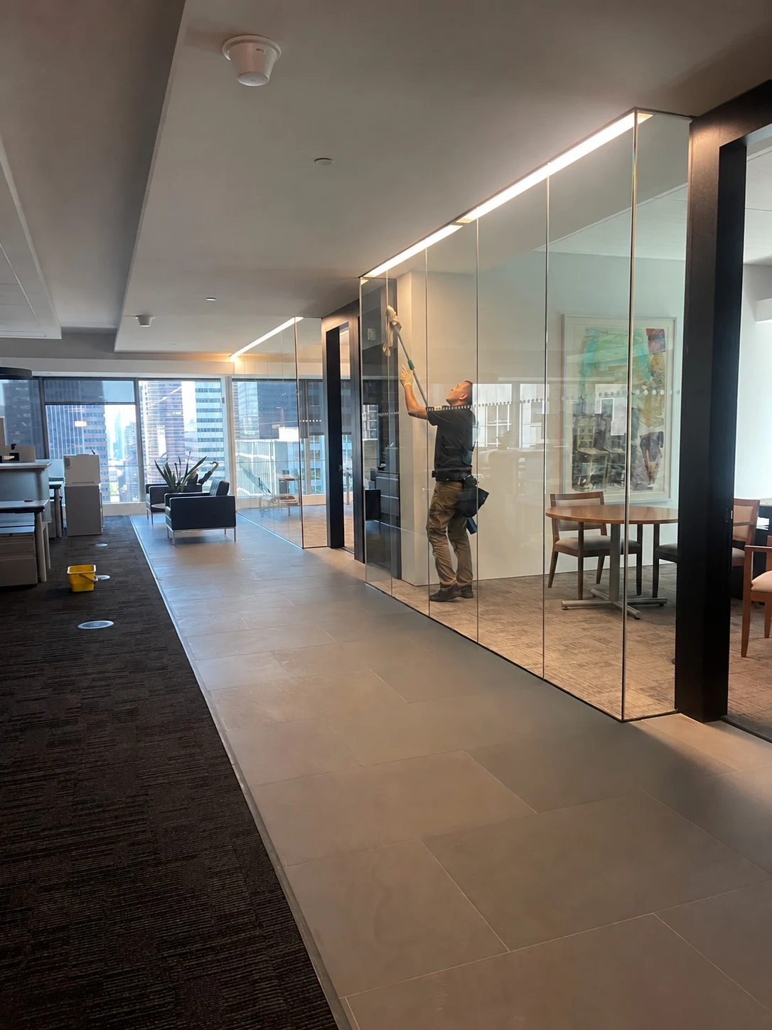 Technician cleaning glass partitions in a finished office